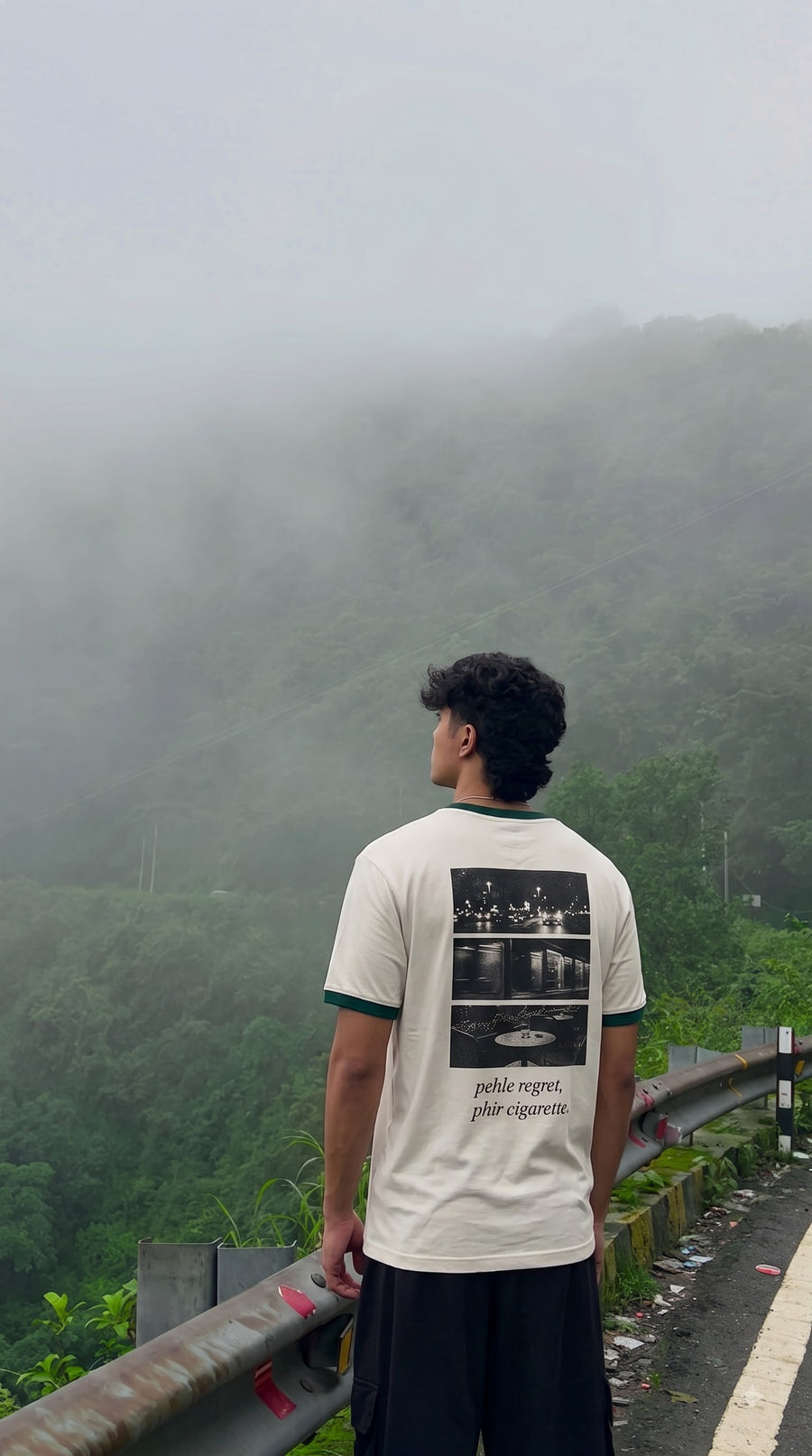 Pehle regret phir cigarette back print worn on a misty green hillside