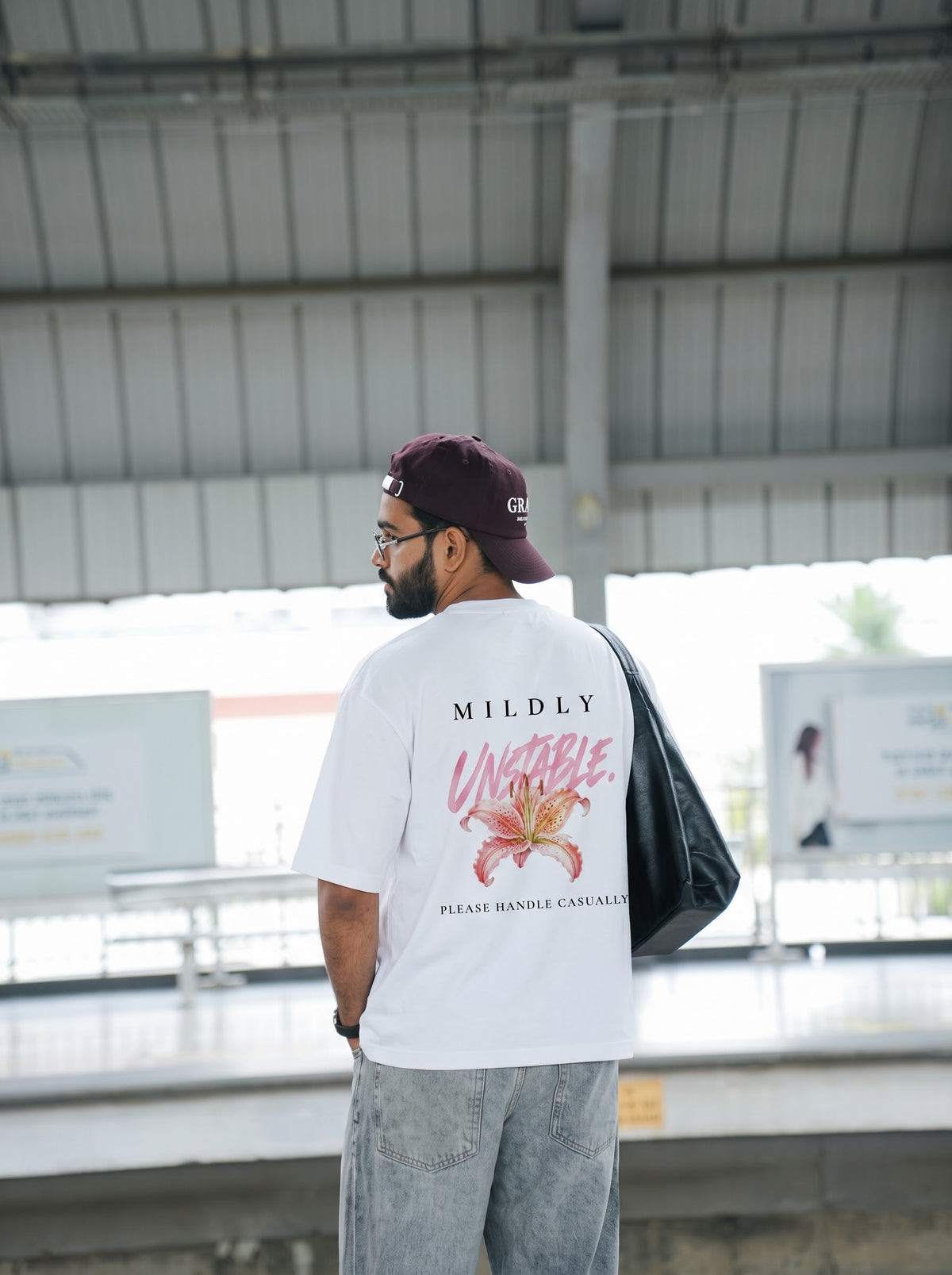 Mildly Unstable back print, pink brush script over a lily above the words please handle casually