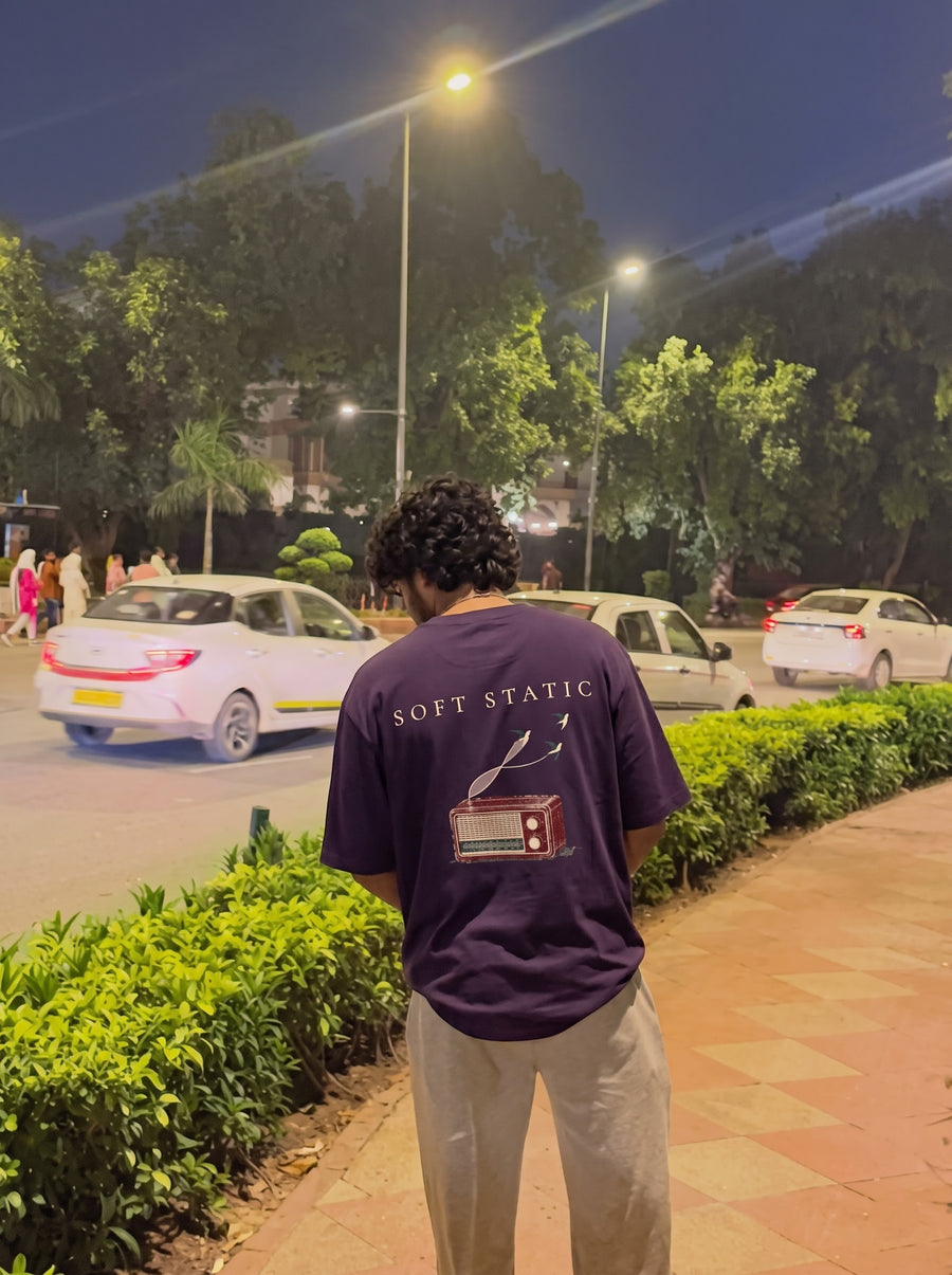 Soft Static back print, an old valve radio, on a purple oversized t-shirt worn at the roadside