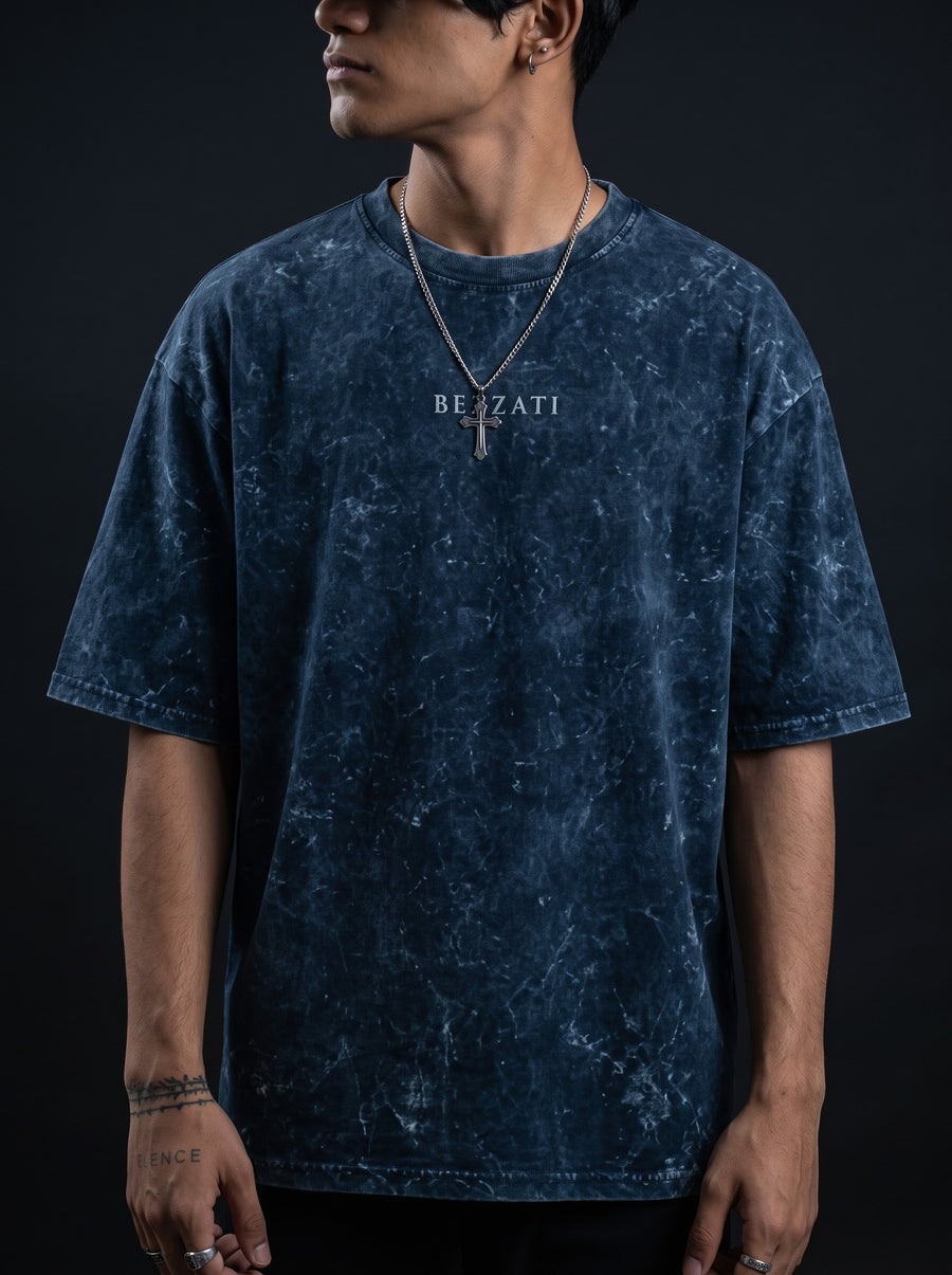 Navy acid-wash oversized t-shirt with the Bezzati chest wordmark, against a dark background
