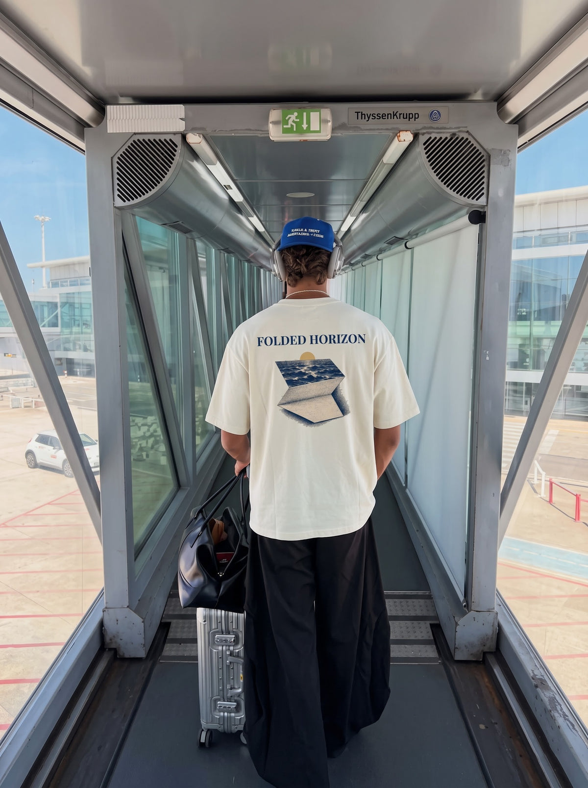 Folded Horizon back print worn walking down an airport jet bridge