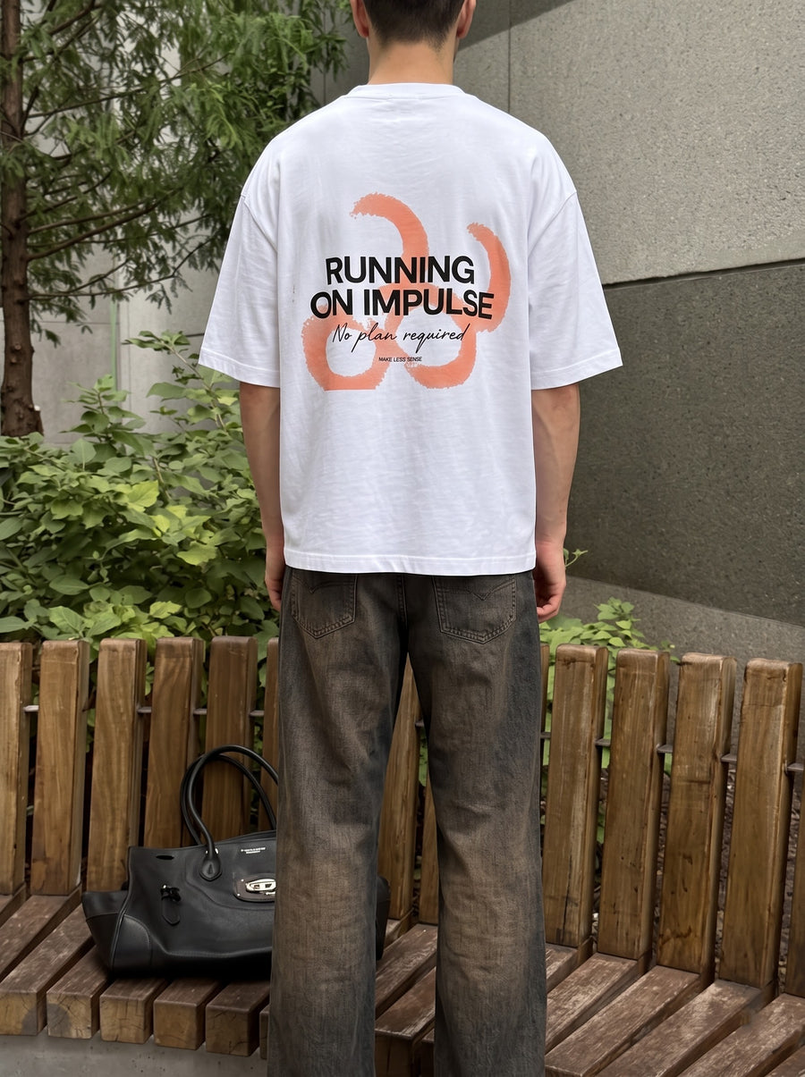 Running On Impulse back print in heavy type over coral brushstrokes, worn beside a wooden fence