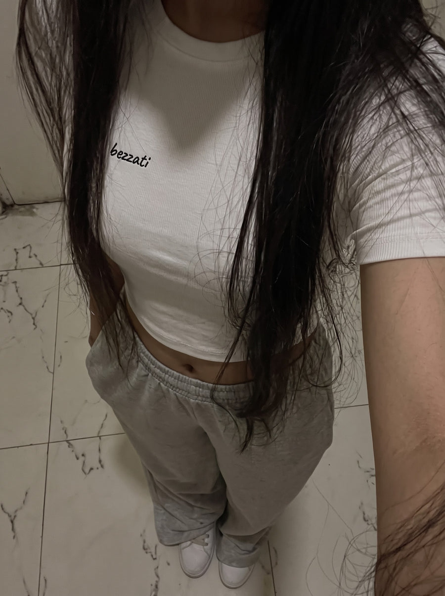 White Too Hot To Function cropped baby tee worn with grey joggers, small bezzati script on the chest