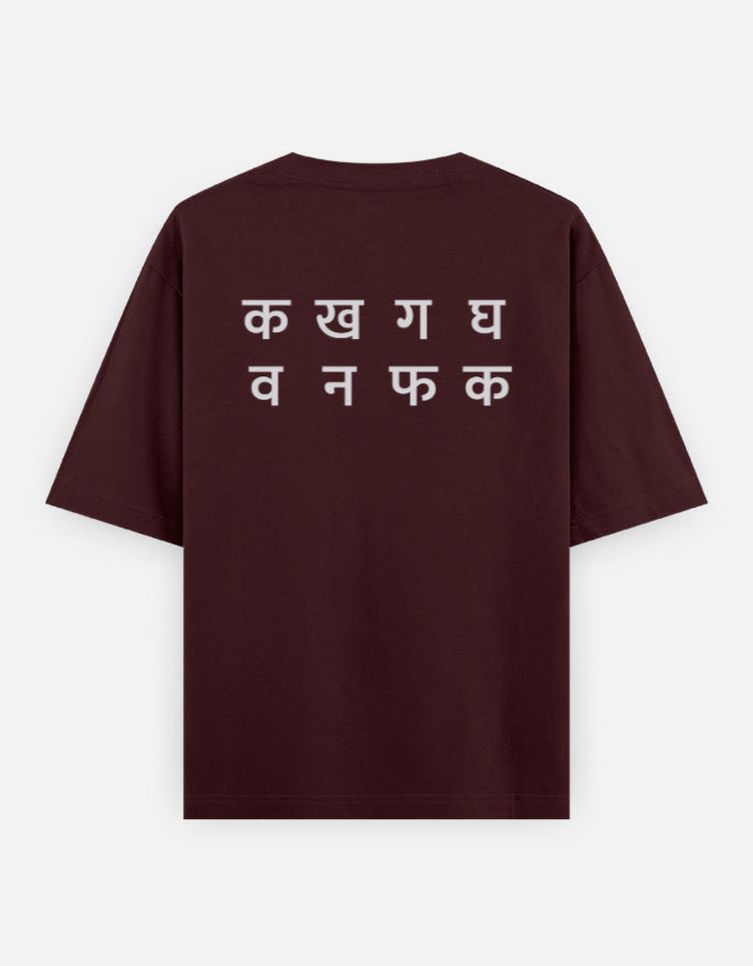Ka Kha Ga back print on the maroon oversized t-shirt: two lines of off-white Devanagari letters, the top line क ख ग घ
