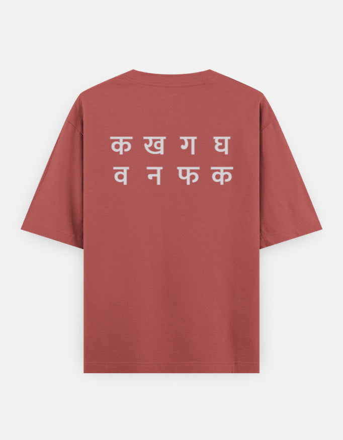 Ka Kha Ga back print on the coral oversized t-shirt: two lines of off-white Devanagari letters, the top line क ख ग घ
