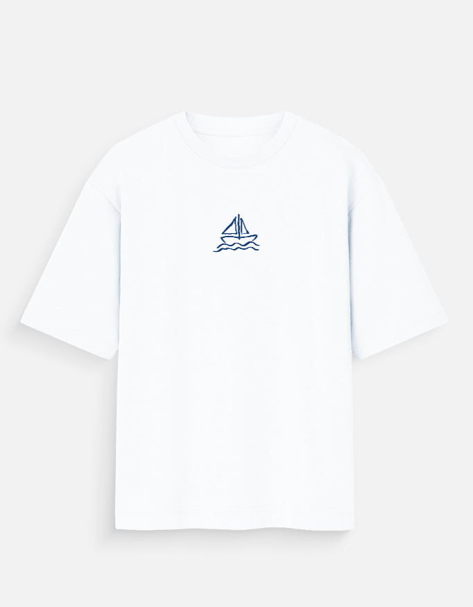 Front of the white Boat oversized t-shirt: a small navy hand-drawn sailboat with two sails on two wavy lines of water, centre chest