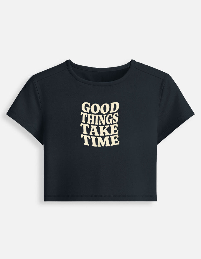 Front of the Navy Blue Good Things Take Time cropped baby tee: Good things take time in wavy cream serif capitals
