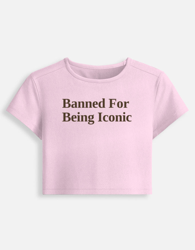 Front of the Banned cropped baby tee in Light Baby Pink: Banned For Being Iconic in dark-brown serif