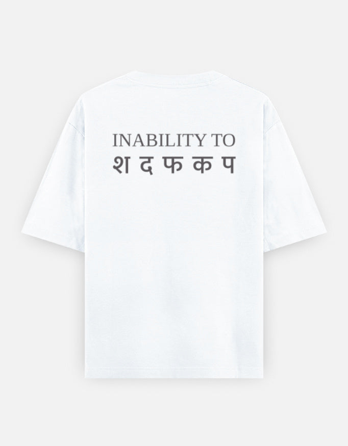 Inability back print on the oversized t-shirt in White: INABILITY TO in charcoal-grey serif capitals above five Devanagari letters