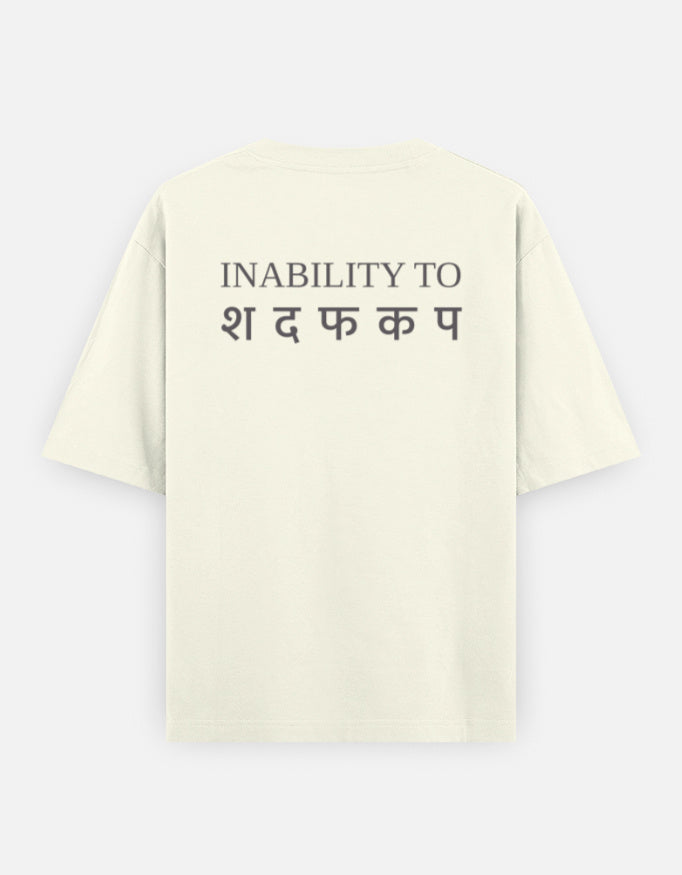 Inability back print on the oversized t-shirt in Off White: INABILITY TO in charcoal-grey serif capitals above five Devanagari letters