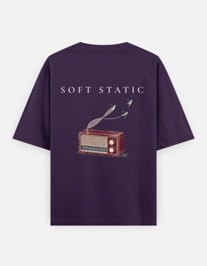 Soft Static back print: an old valve radio with two birds lifting out of the sound, on a purple oversized t-shirt